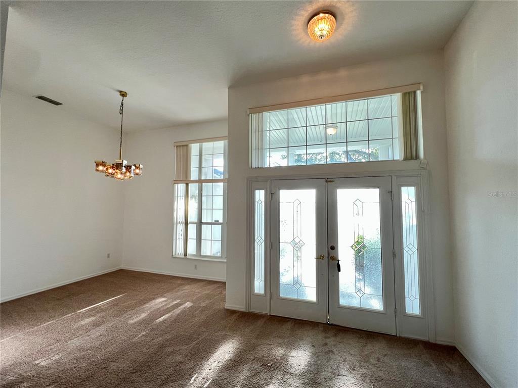 11159 Southwest 71st Terrace Road Ocala, FL 34476 - Photo 3 of 25 an empty room with windows and entrance