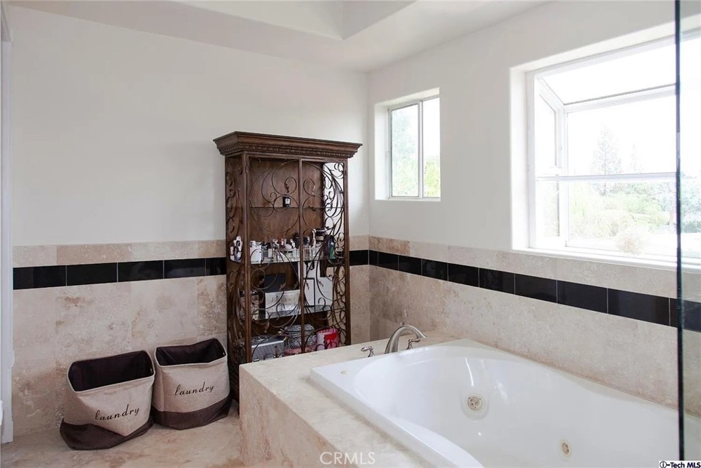 10062 Valley Cir Boulevard Chatsworth, CA 91311 - Photo 24 of 35 a bathroom with a bathtub and a window