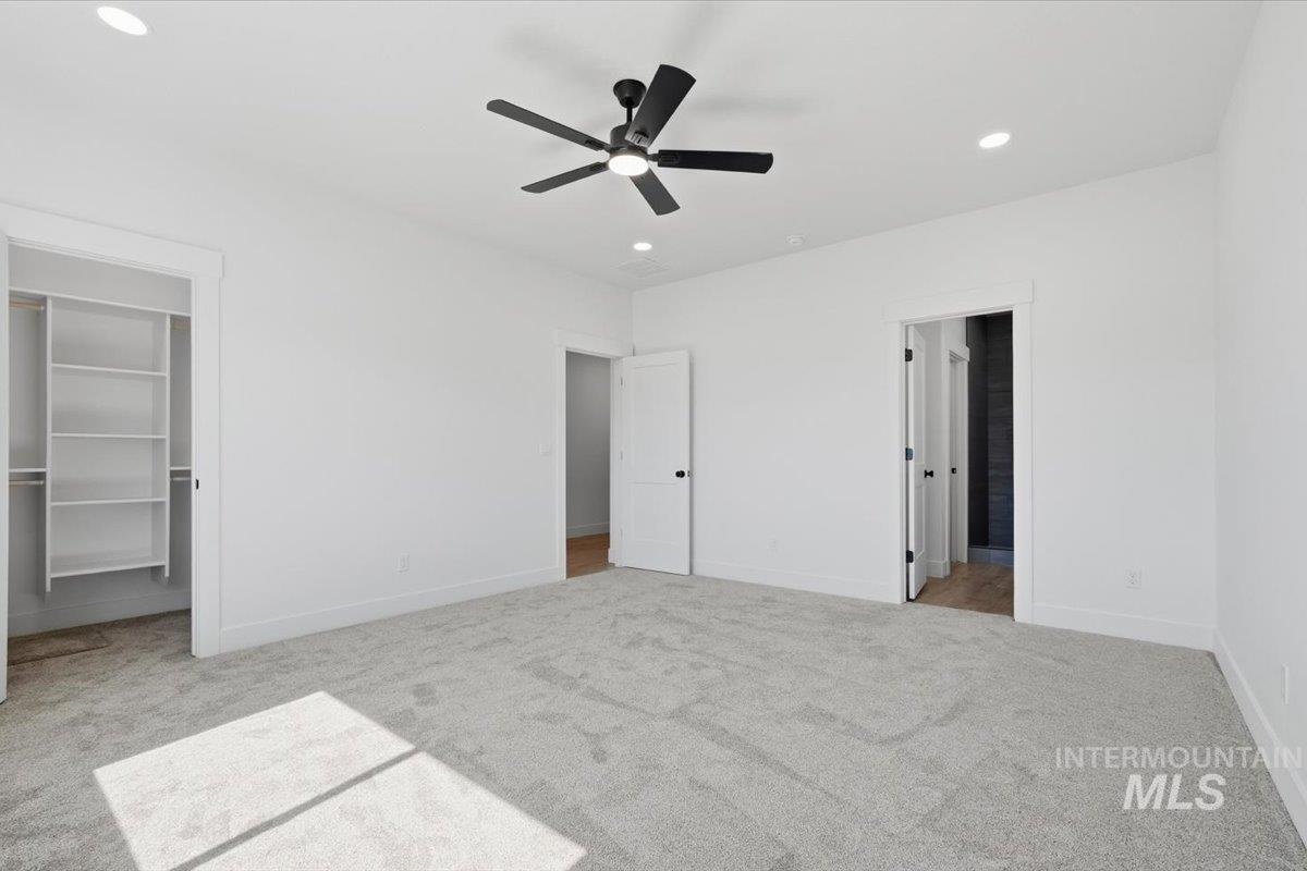 2173 Austin Way Fruitland, ID 83619 - Photo 18 of 28 Unfurnished bedroom featuring a spacious closet, light carpet, connected bathroom, a ceiling fan, and recessed lighting
