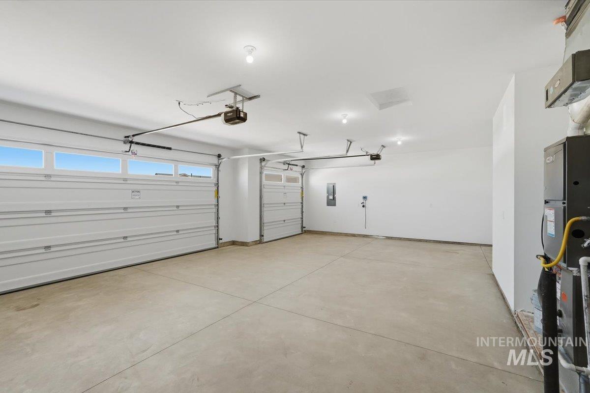2173 Austin Way Fruitland, ID 83619 - Photo 26 of 28 Garage with electric panel, heating unit, and a garage door opener