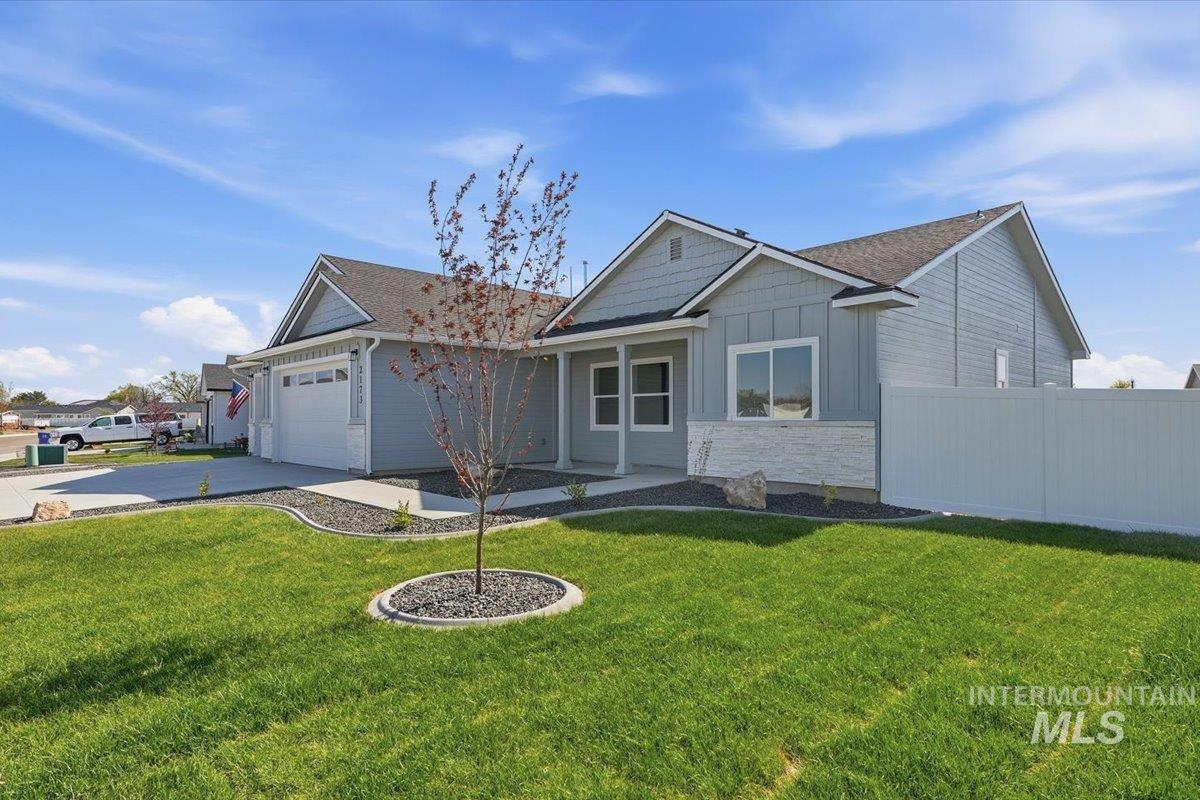 2173 Austin Way Fruitland, ID 83619 - Photo 4 of 28 View of front of home with board and batten siding, a garage, stone siding, driveway, and covered porch