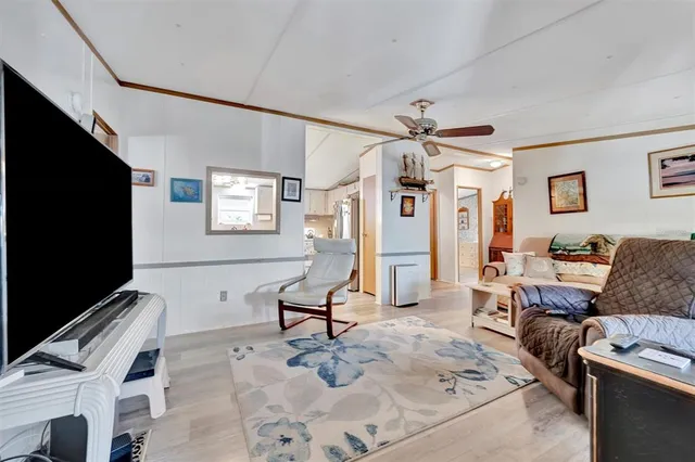a living room with furniture a flat screen tv and a window