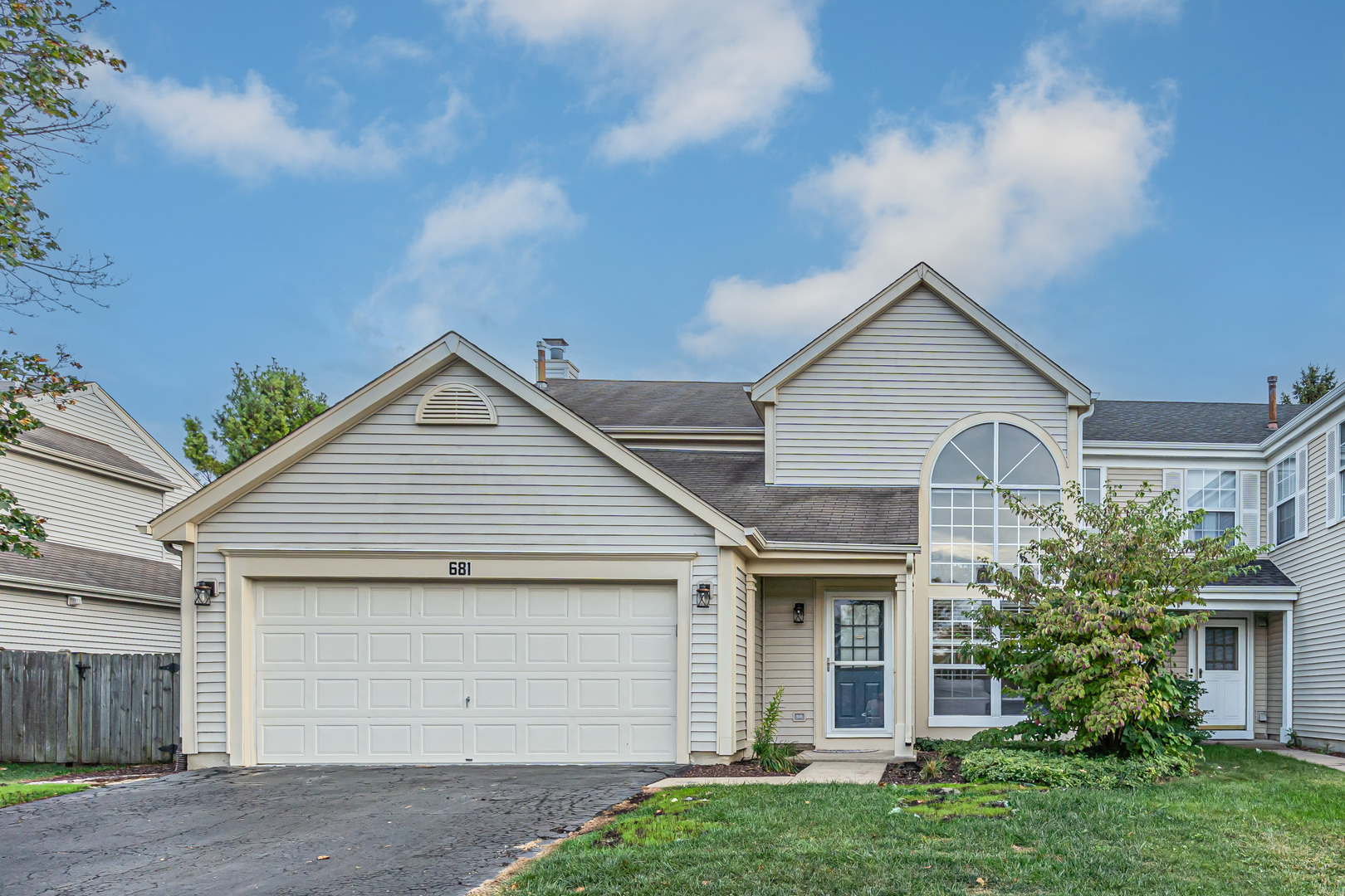 a front view of white house with a yard