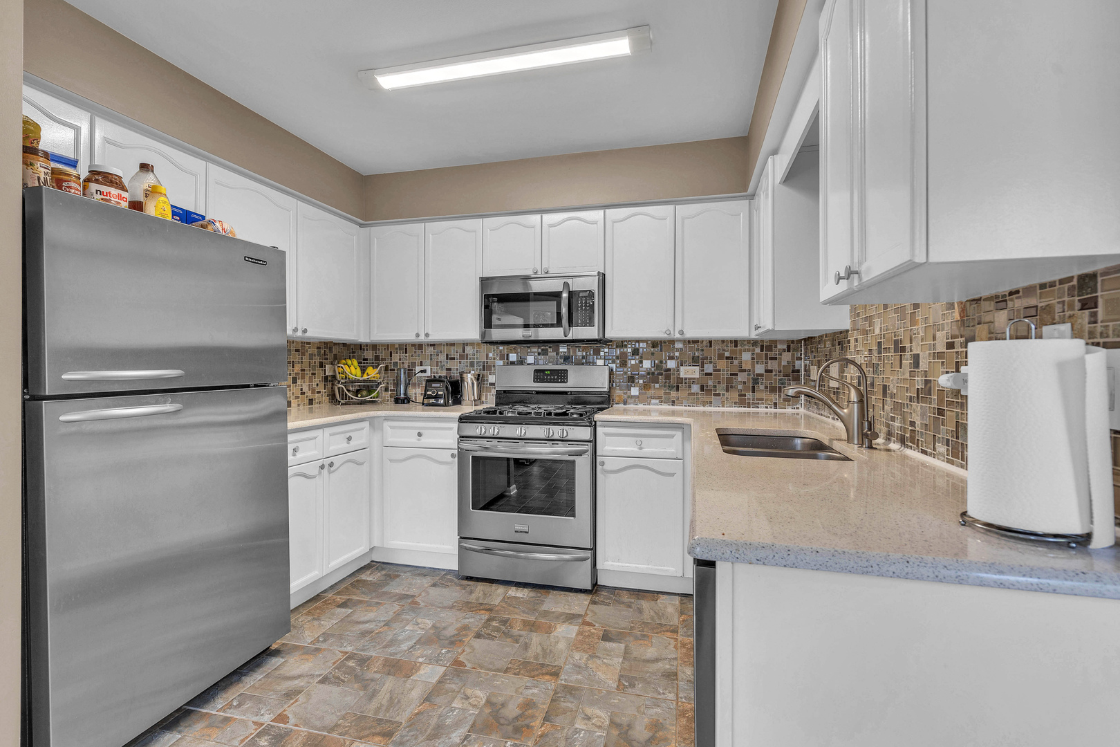 681 Legends Drive Carol Stream, IL 60188 - Photo 27 of 34 a kitchen with a refrigerator sink and white cabinets