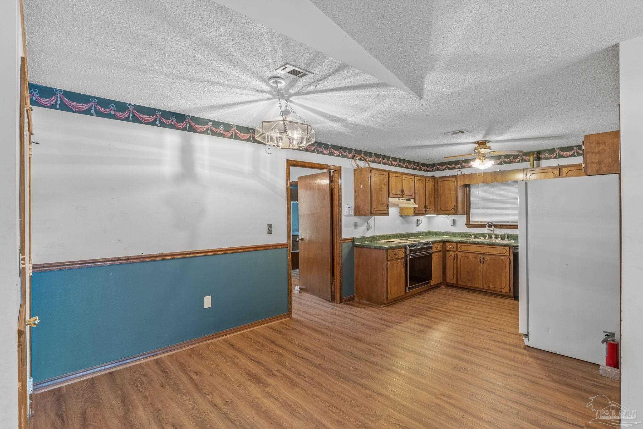 426 Brown Place Crestview, FL 32539 - Photo 12 of 40 a kitchen with stainless steel appliances granite countertop a refrigerator a sink dishwasher a stove with wooden floors