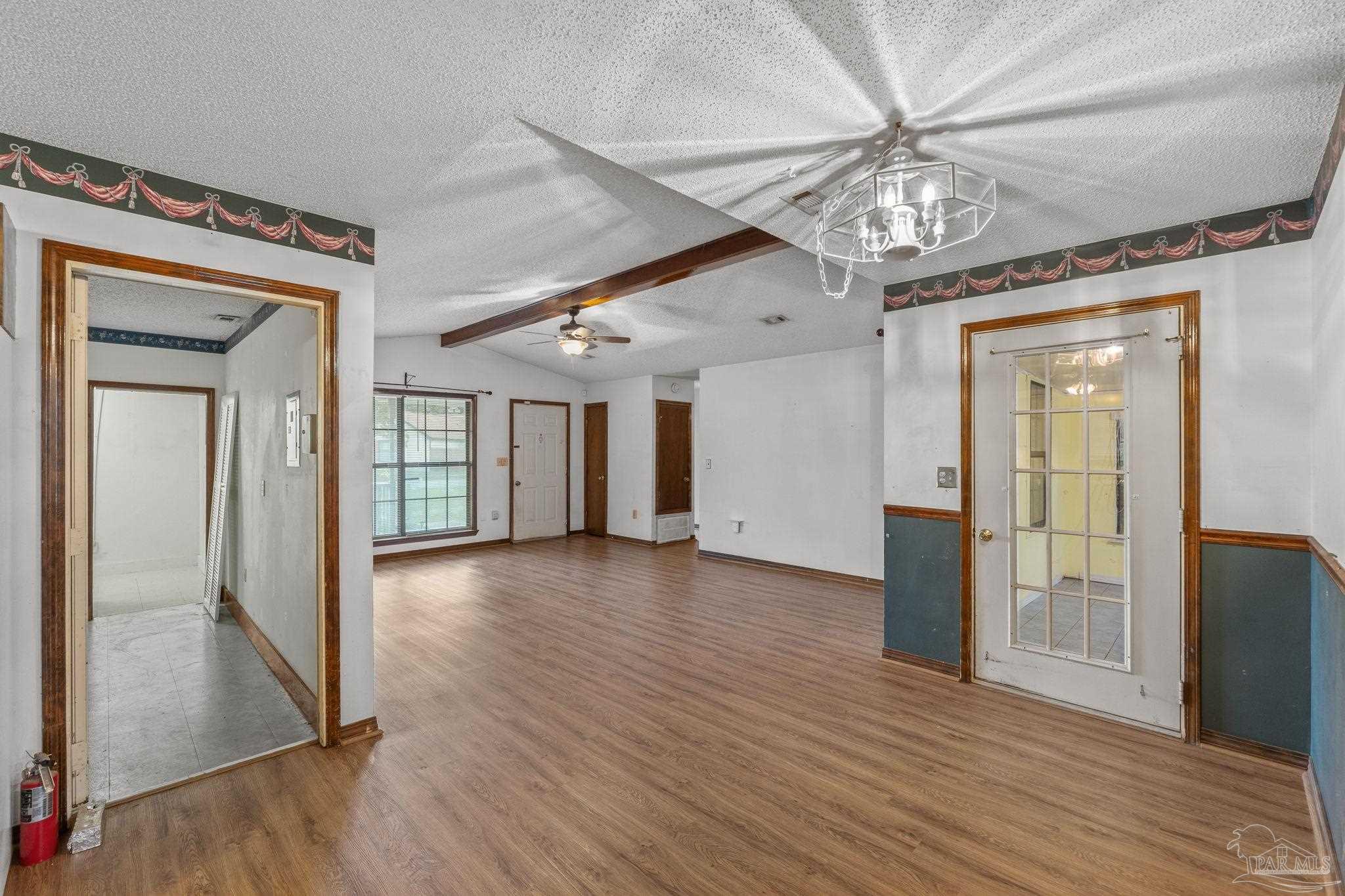 426 Brown Place Crestview, FL 32539 - Photo 13 of 40 an empty room with wooden floor chandelier and windows