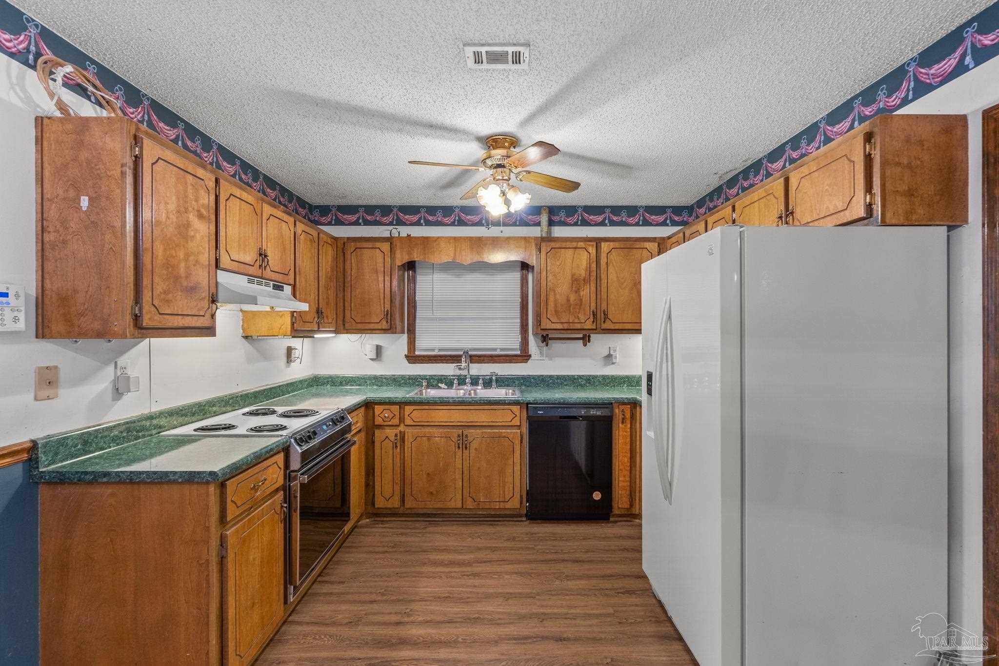 426 Brown Place Crestview, FL 32539 - Photo 15 of 40 a kitchen with stainless steel appliances granite countertop a sink stove and refrigerator
