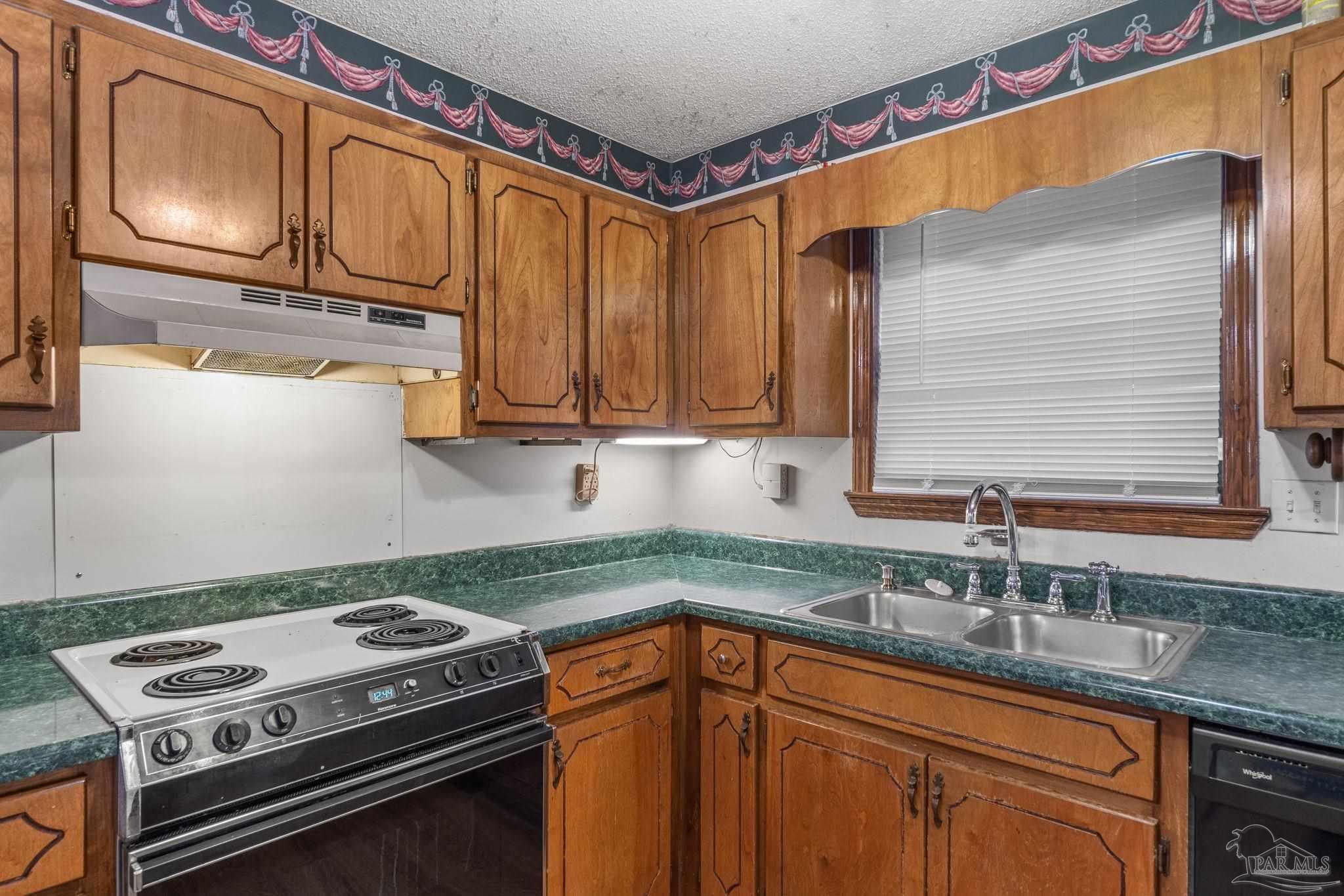 426 Brown Place Crestview, FL 32539 - Photo 16 of 40 a kitchen with stainless steel appliances granite countertop a sink stove and cabinets