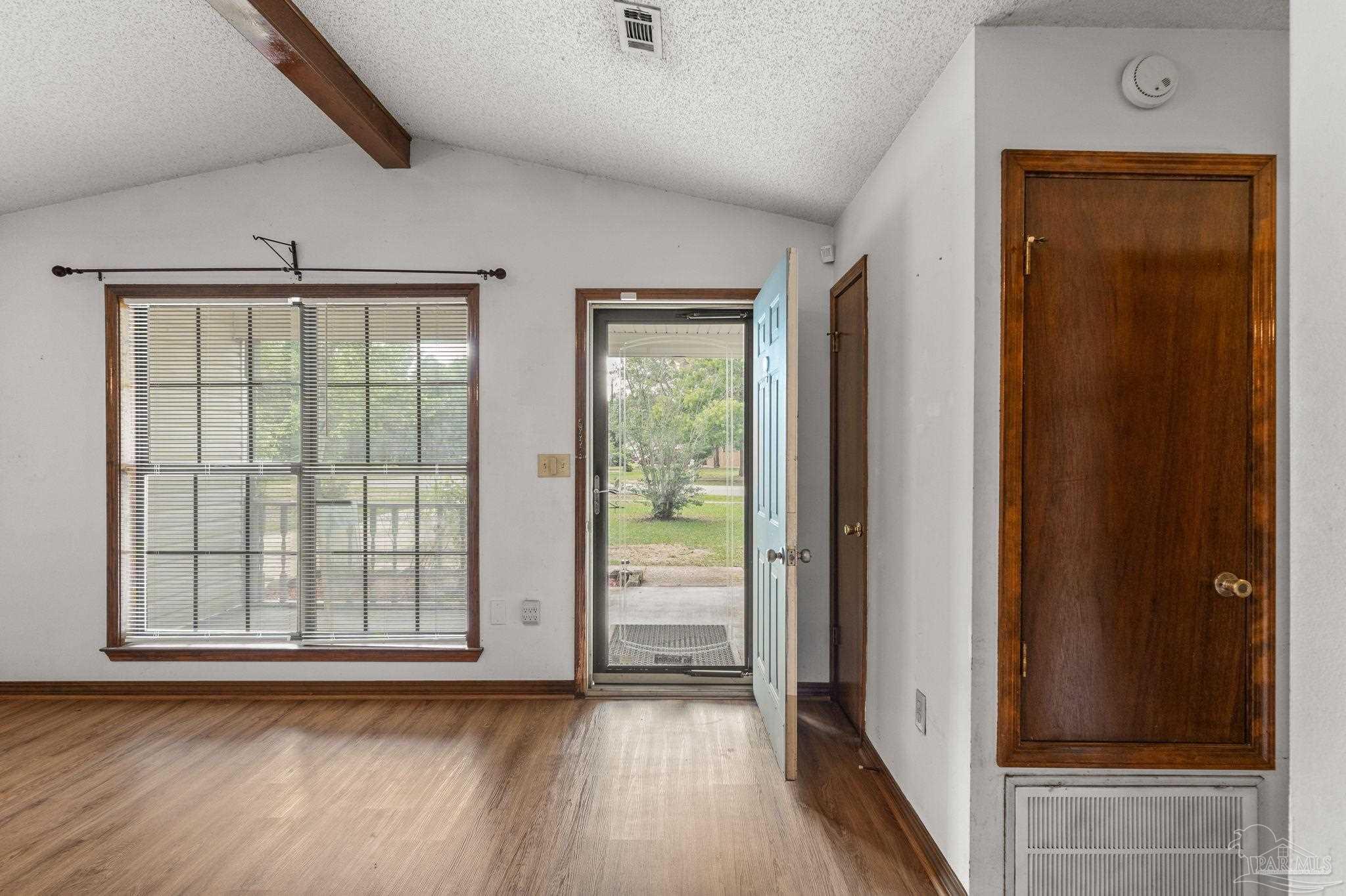 426 Brown Place Crestview, FL 32539 - Photo 8 of 40 an empty room with wooden floor and windows