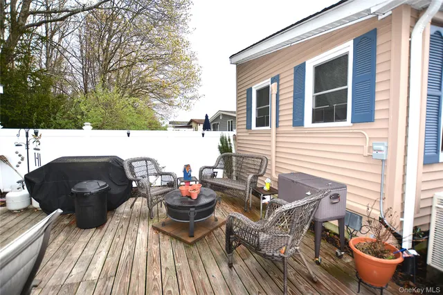 a view of a patio with table and chairs with wooden floor and fence