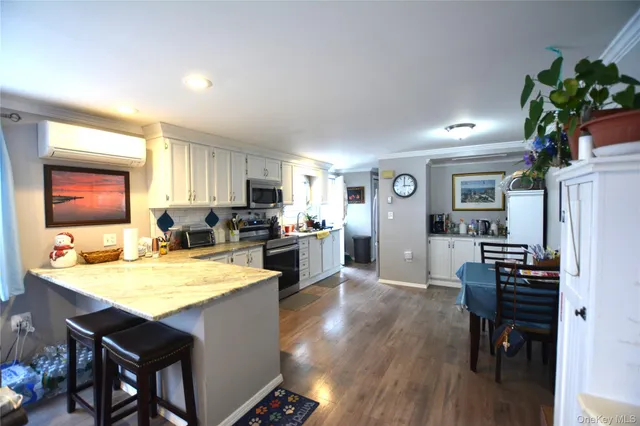 a open kitchen with a table chairs refrigerator and microwave