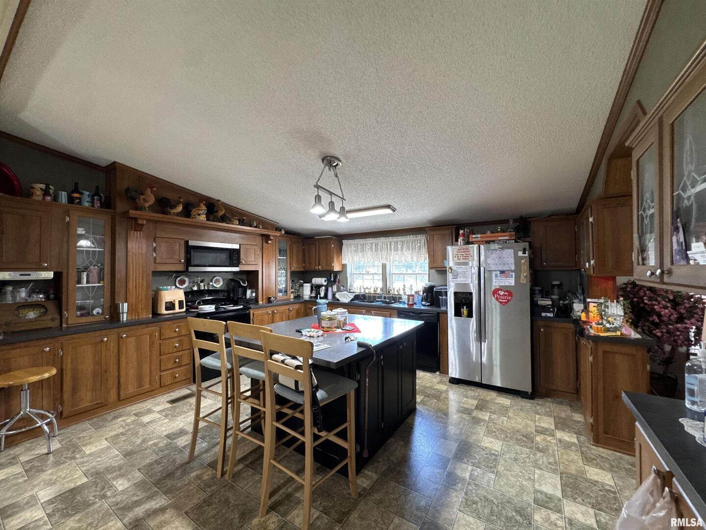 3920 Herrin Road Carterville, IL 62918 - Photo 8 of 34 a kitchen with stainless steel appliances kitchen island granite countertop a table chairs sink and cabinets