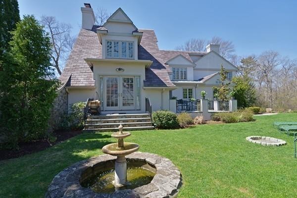 77 Cliff Road Wellesley, MA 02481 - Photo 20 of 29 a front view of a house with a garden and plants