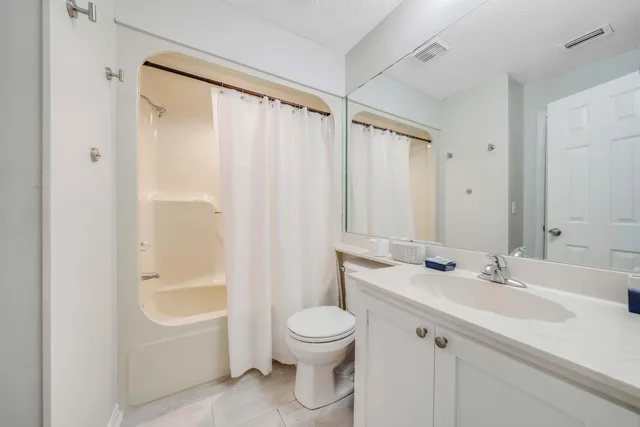 a bathroom with a sink a toilet and a large mirror