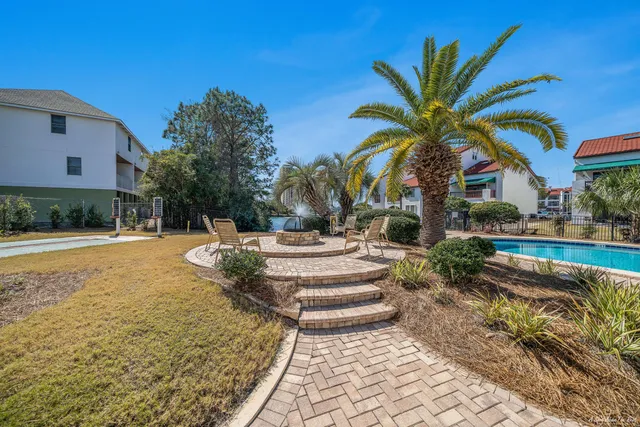 a view of swimming pool with outdoor seating and house in the background