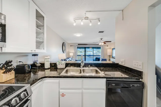 a kitchen with granite countertop a sink and cabinets