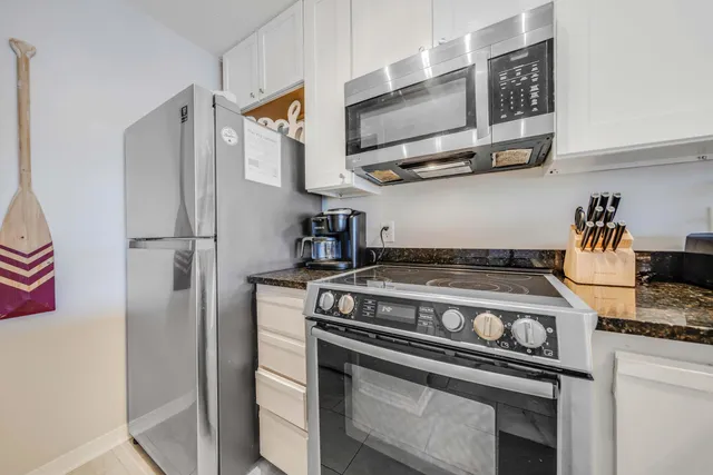 a kitchen with stainless steel appliances granite countertop a stove and a refrigerator