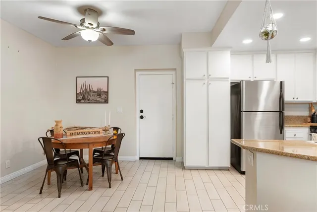 a dining room with furniture and a refrigerator