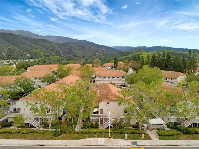 an aerial view of a house with a yard and a large tree