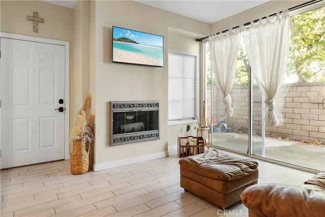 a living room with furniture a large window and a fireplace