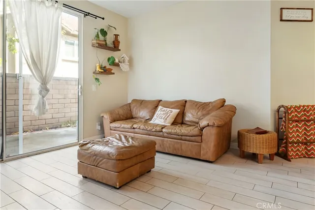 a living room with furniture and a floor to ceiling window