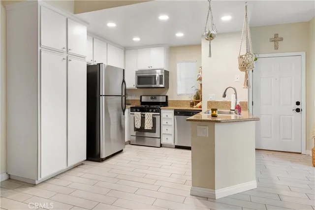 a kitchen with kitchen island granite countertop a refrigerator stove top oven and sink