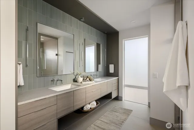 a bathroom with double vanity sinks a mirror and a shower