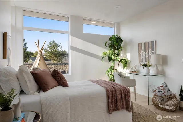 a bedroom with bed and a potted plant