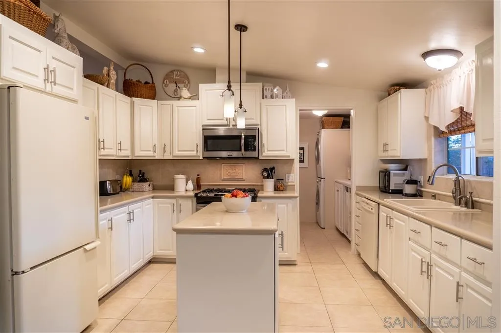 39325 De Luz Road Fallbrook, CA 92028 - Photo 13 of 25 a kitchen with stainless steel appliances kitchen island granite countertop a refrigerator sink and cabinets