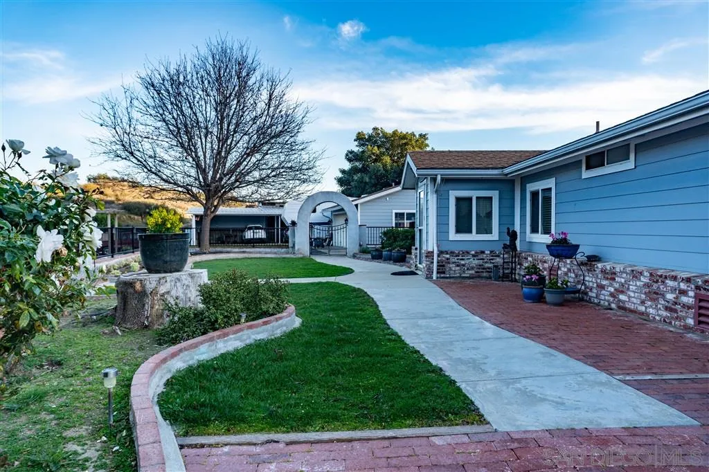 39325 De Luz Road Fallbrook, CA 92028 - Photo 4 of 25 a front view of a house with garden and trees