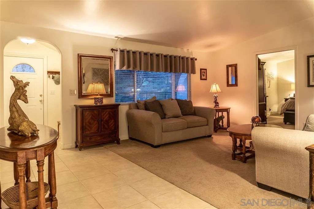 39325 De Luz Road Fallbrook, CA 92028 - Photo 8 of 25 a living room with furniture a flat screen tv and a wall painting
