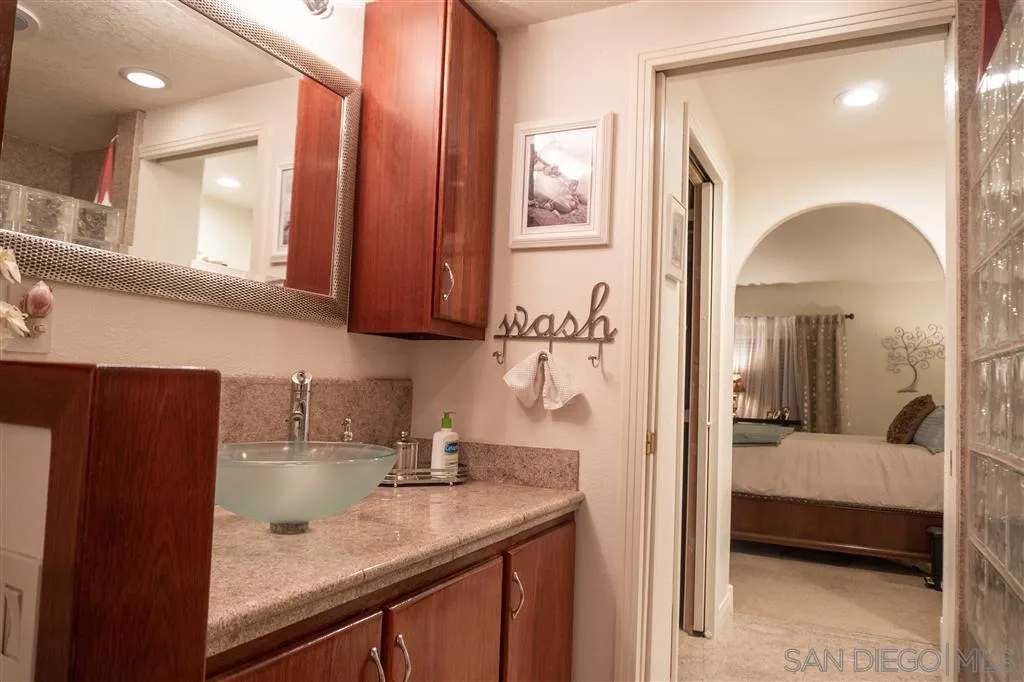 39325 De Luz Road Fallbrook, CA 92028 - Photo 10 of 25 a en suite bathroom with a sink a mirror and next to a window