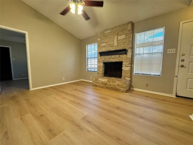a view of an empty room with a fireplace and a window