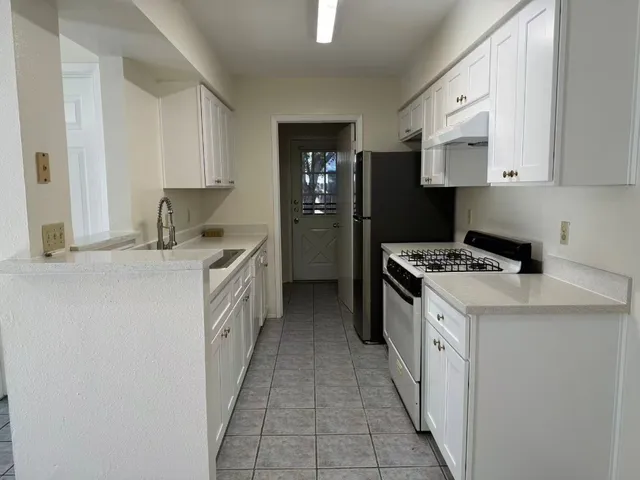 a kitchen with a sink a stove and cabinets