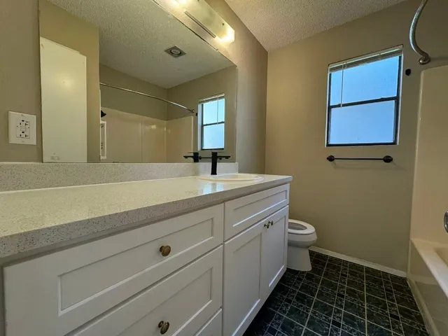 a bathroom with a sink mirror vanity and toilet