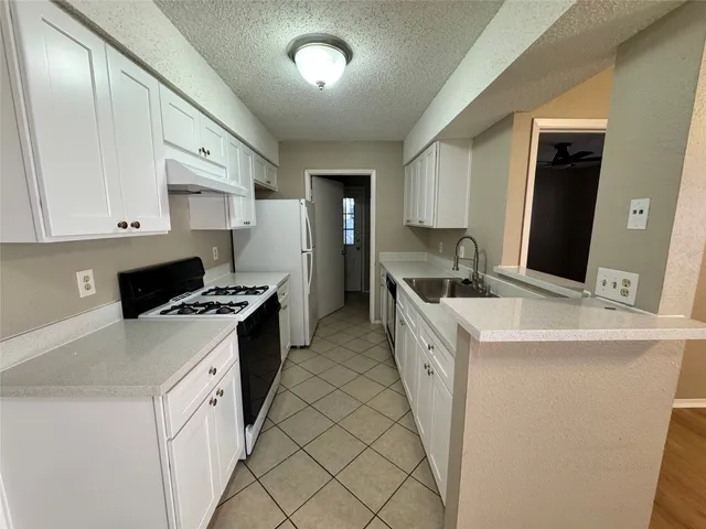 a kitchen with a sink stove and refrigerator