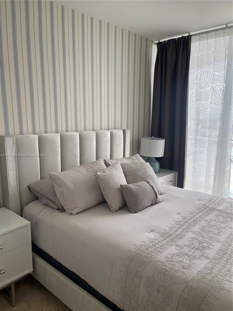 6365 Collins Avenue, Unit 2610 Miami Beach, FL 33141 - Photo 15 of 49 a bedroom with a bed and a curtain