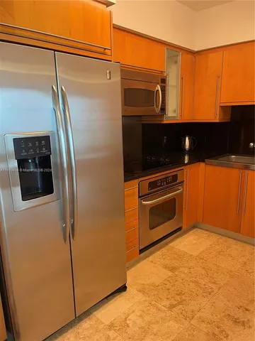 a view of kitchen with stainless steel appliances granite countertop cabinets and a wooden floor