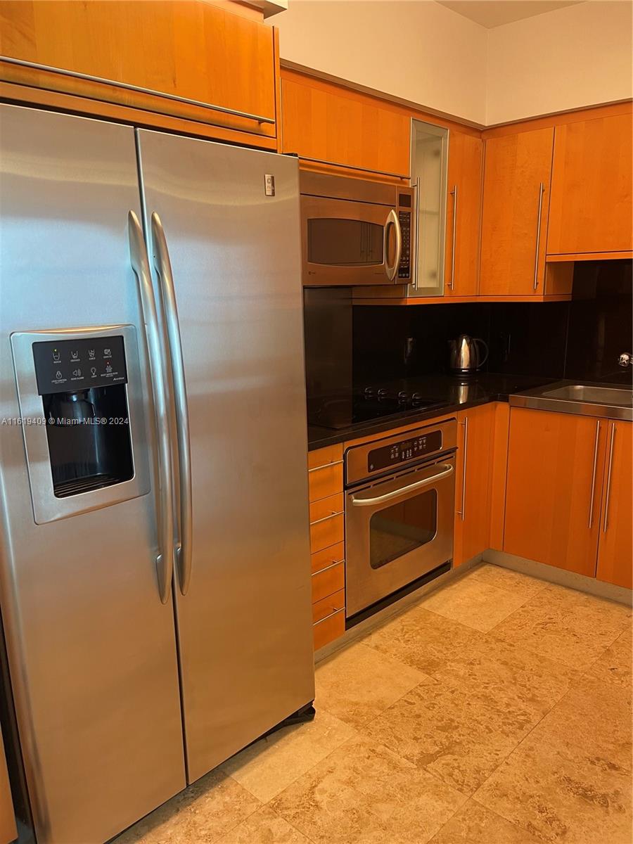 6365 Collins Avenue, Unit 2610 Miami Beach, FL 33141 - Photo 20 of 49 a kitchen with stainless steel appliances granite countertop a refrigerator and a stove top oven