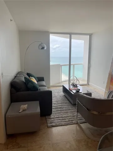 a living room with stainless steel appliances granite countertop a stove and a large window