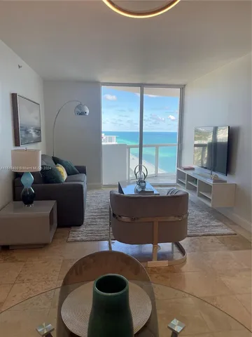 a living room with furniture and a floor to ceiling window