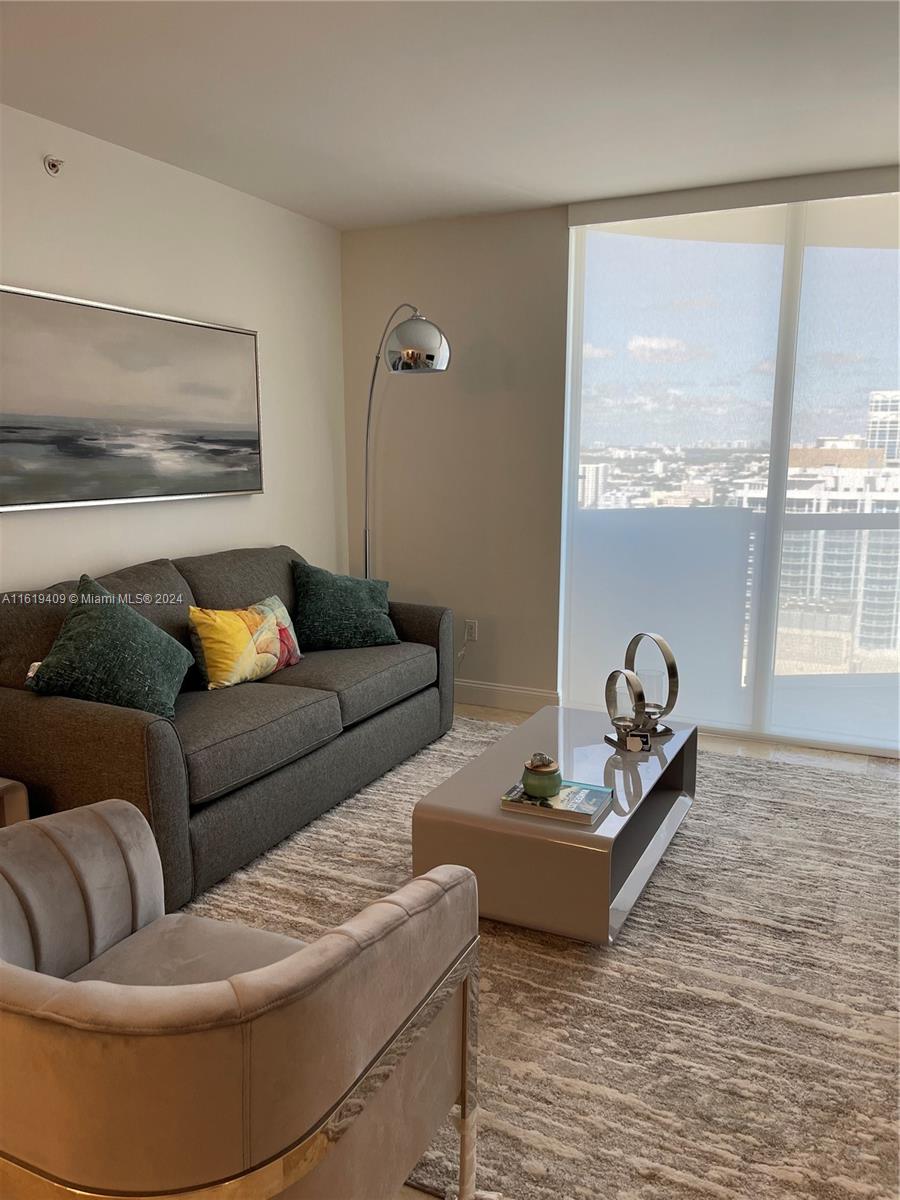 6365 Collins Avenue, Unit 2610 Miami Beach, FL 33141 - Photo 38 of 49 a living room with furniture and a floor to ceiling window