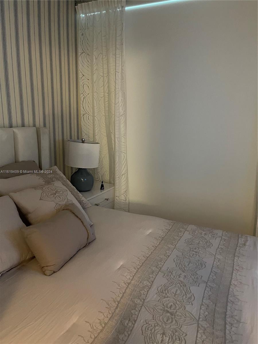 6365 Collins Avenue, Unit 2610 Miami Beach, FL 33141 - Photo 42 of 49 a bedroom with a bed and curtain