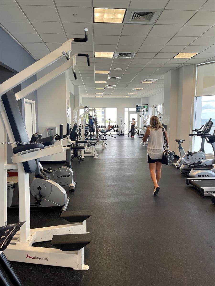 6365 Collins Avenue, Unit 2610 Miami Beach, FL 33141 - Photo 47 of 49 a room with gym equipment and a table