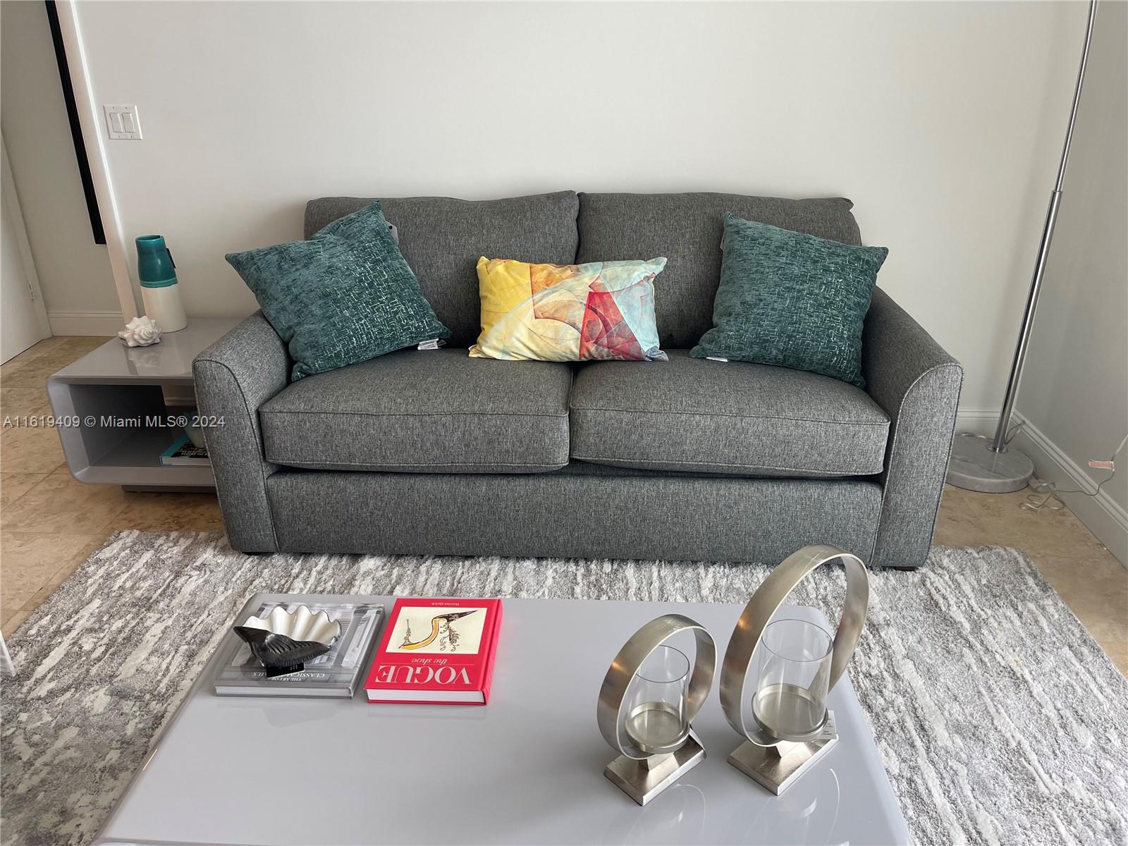 6365 Collins Avenue, Unit 2610 Miami Beach, FL 33141 - Photo 9 of 49 a living room with a couch and a table