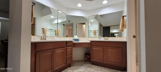a bathroom with double vanity and a mirror