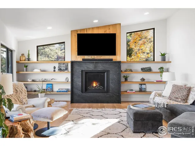 a living room with furniture a flat screen tv and a fireplace