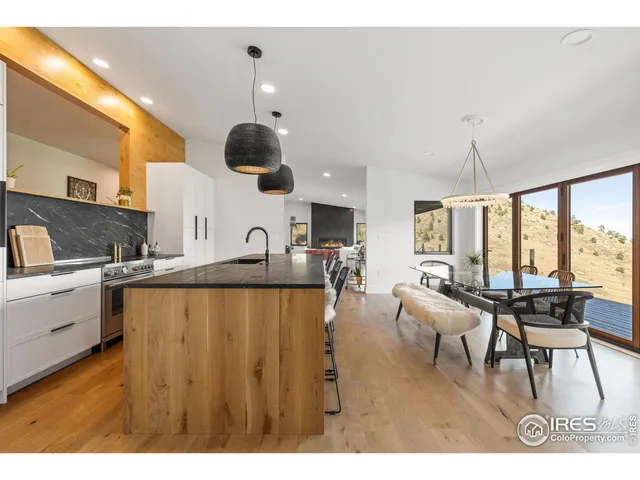 a living room with stainless steel appliances kitchen island granite countertop furniture and a large window