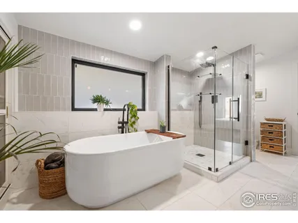 a spacious bathroom with a tub sink shower and mirror