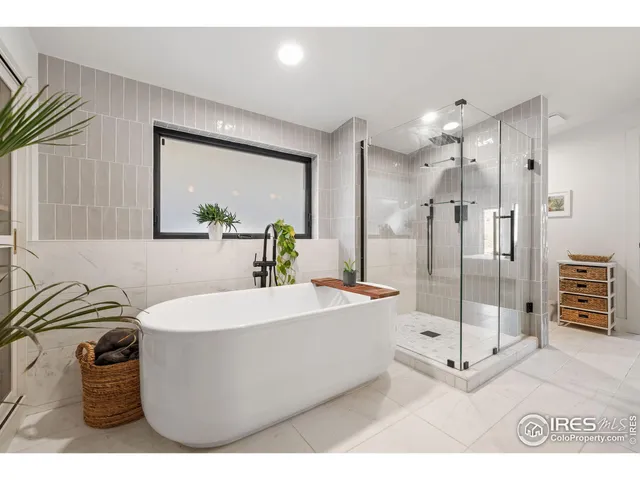 a spacious bathroom with a tub sink shower and mirror